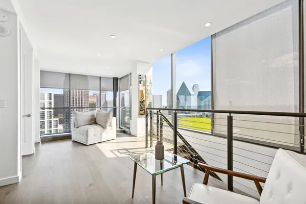 a view of a hallway with wooden floor and furniture