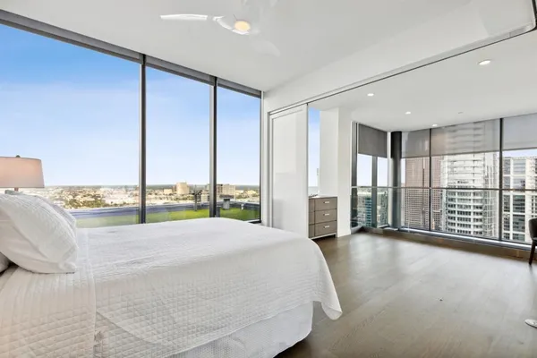 a bedroom with a bed and a large window