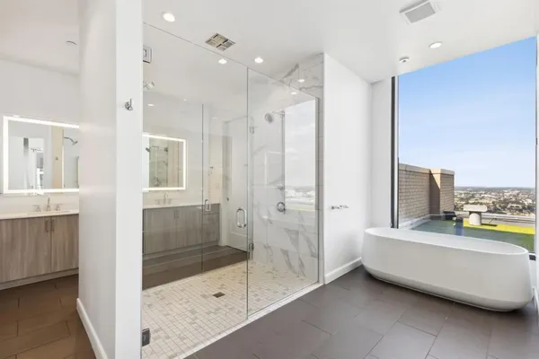 a spacious bedroom with a large window and a balcony