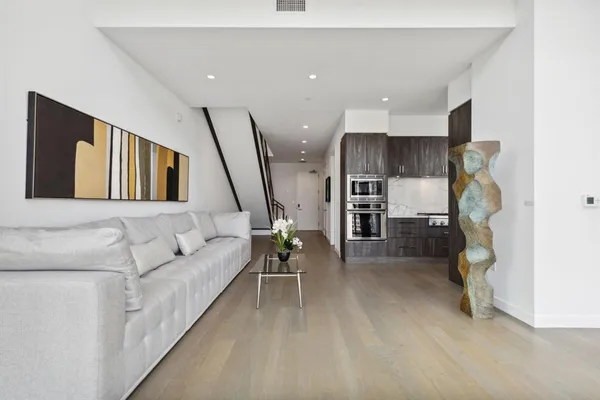 a living room with furniture and a wooden floor