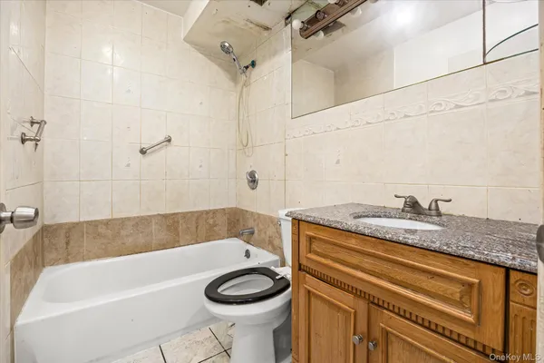 a bathroom with a granite countertop sink a toilet and bathtub