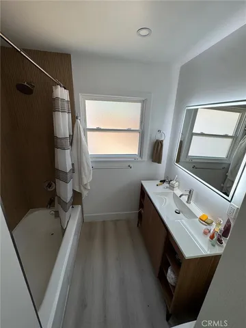 a bathroom with a tub sink and mirror