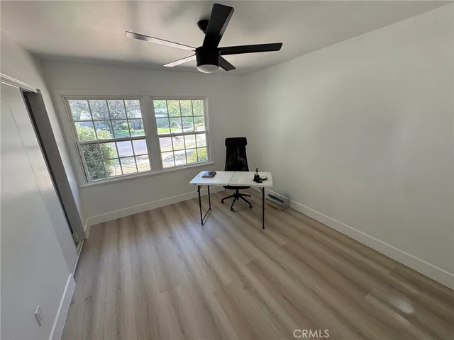 a view of a workspace with furniture and a window