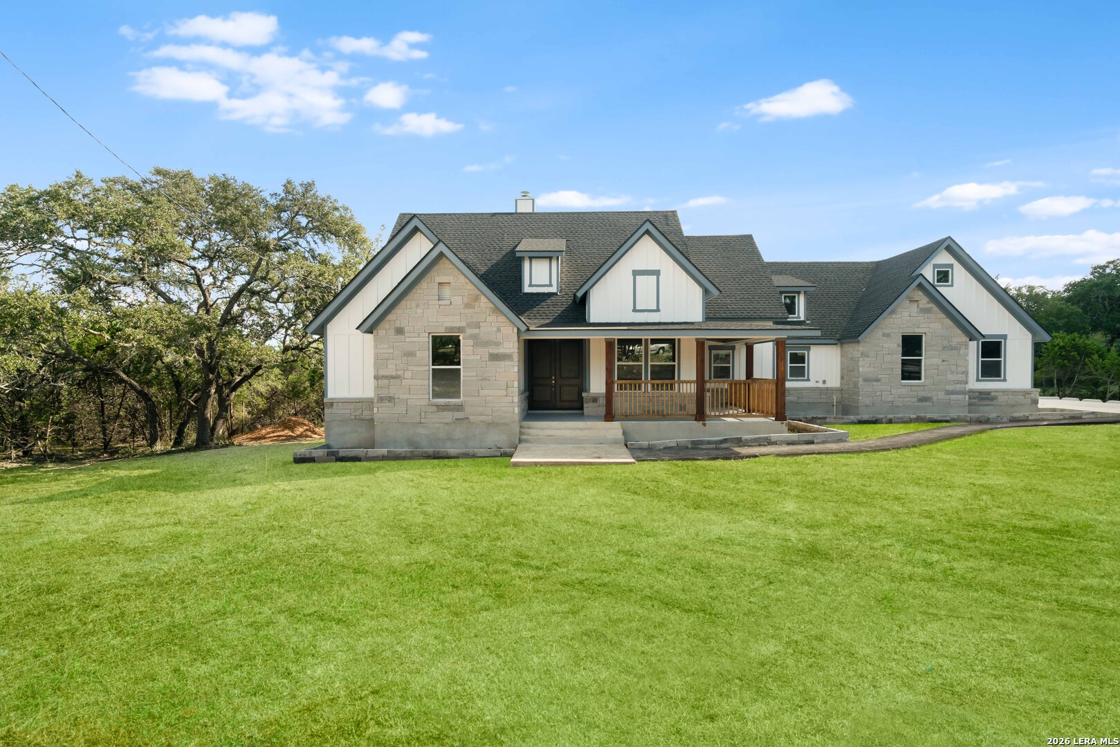 11608 Oak Country Helotes, TX 78023 - Photo 1 of 19 a front view of a house with a garden and porch