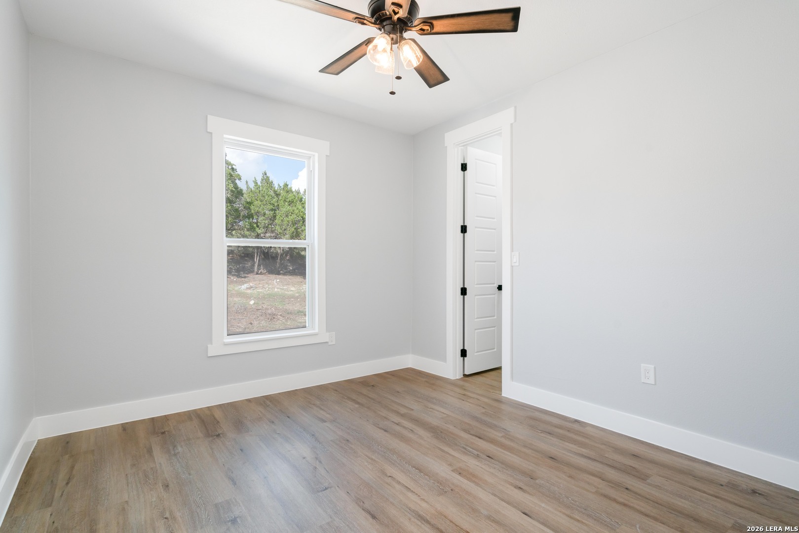 11608 Oak Country Helotes, TX 78023 - Photo 4 of 19 an empty room with wooden floor chandelier fan and windows