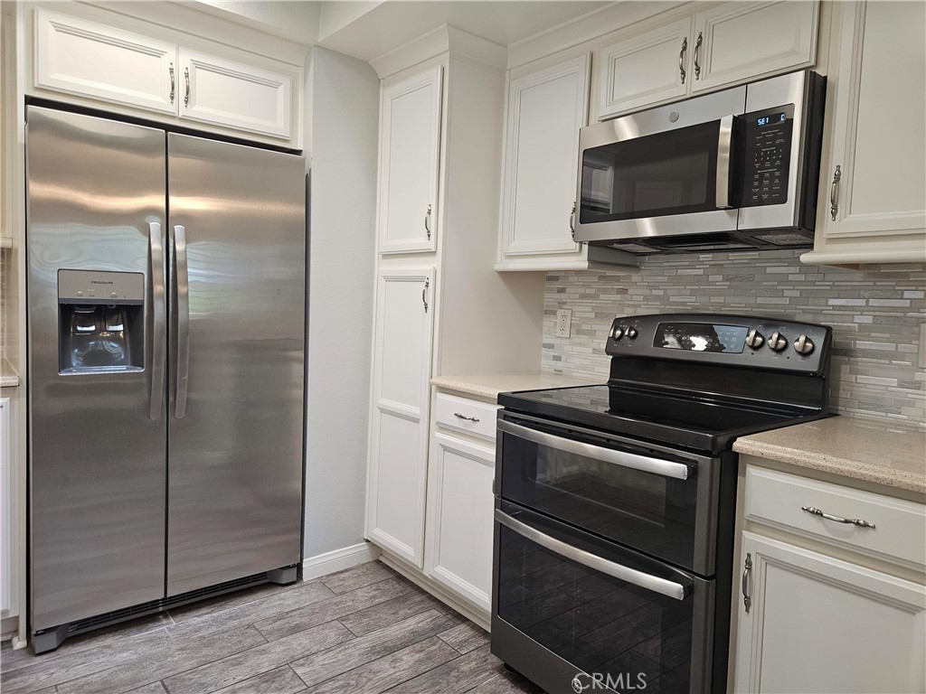 8933 Biscayne Court, Unit 221H Huntington Beach, CA 92646 - Photo 2 of 13 a kitchen with a refrigerator stove and microwave