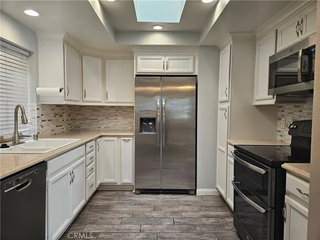a kitchen with a refrigerator sink and cabinets