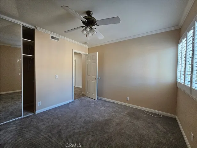 an empty room with windows and fan