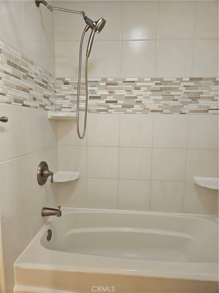 8933 Biscayne Court, Unit 221H Huntington Beach, CA 92646 - Photo 8 of 13 a bathroom with a bath tub and shower