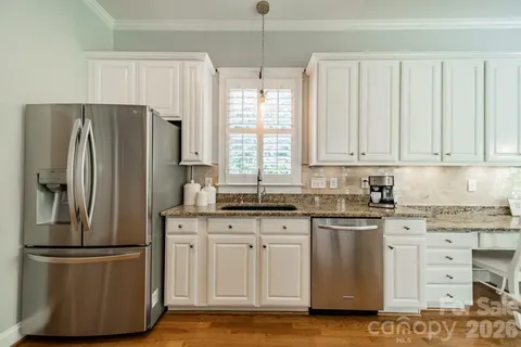 a kitchen with stainless steel appliances granite countertop a refrigerator sink and cabinets