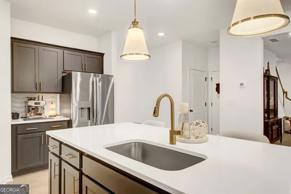 a kitchen with kitchen island a sink appliances and a counter top space