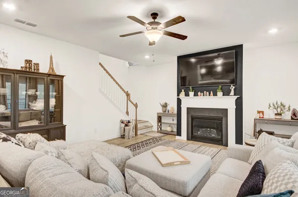a living room with furniture a flat screen tv and a fireplace