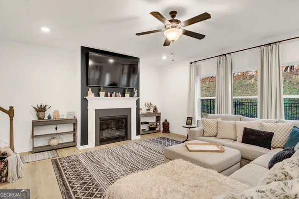 a living room with furniture a flat screen tv and a fireplace