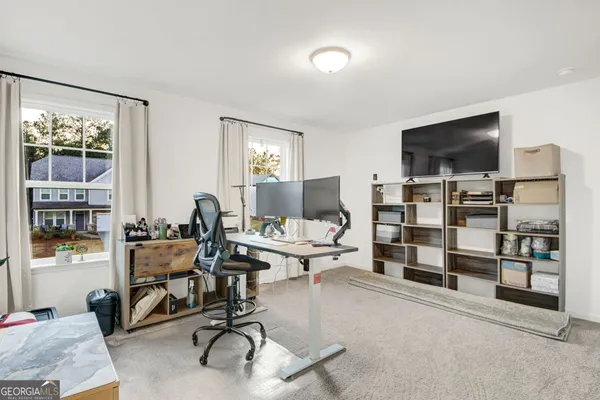 a view of a livingroom with workspace and a window