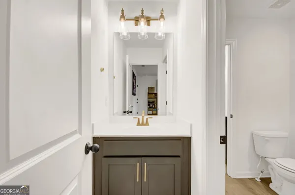 a bathroom with a sink vanity mirror and toilet