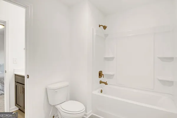 a bathroom with a toilet and a bath tub