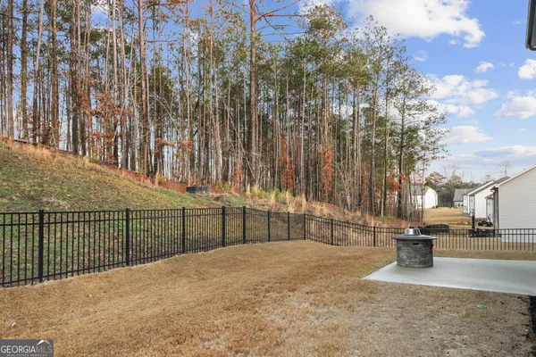 a view of backyard with wooden fence
