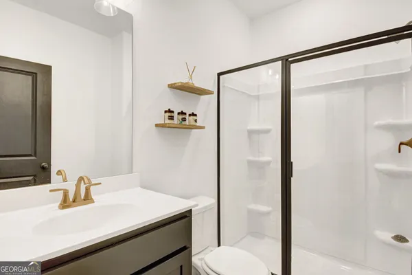 a bathroom with a sink vanity mirror and toilet