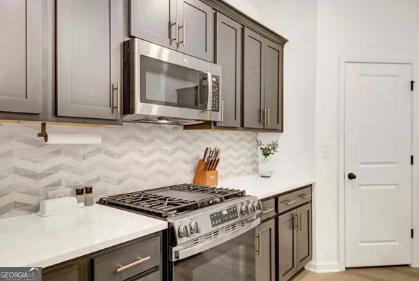 a kitchen with granite countertop a stove and a microwave