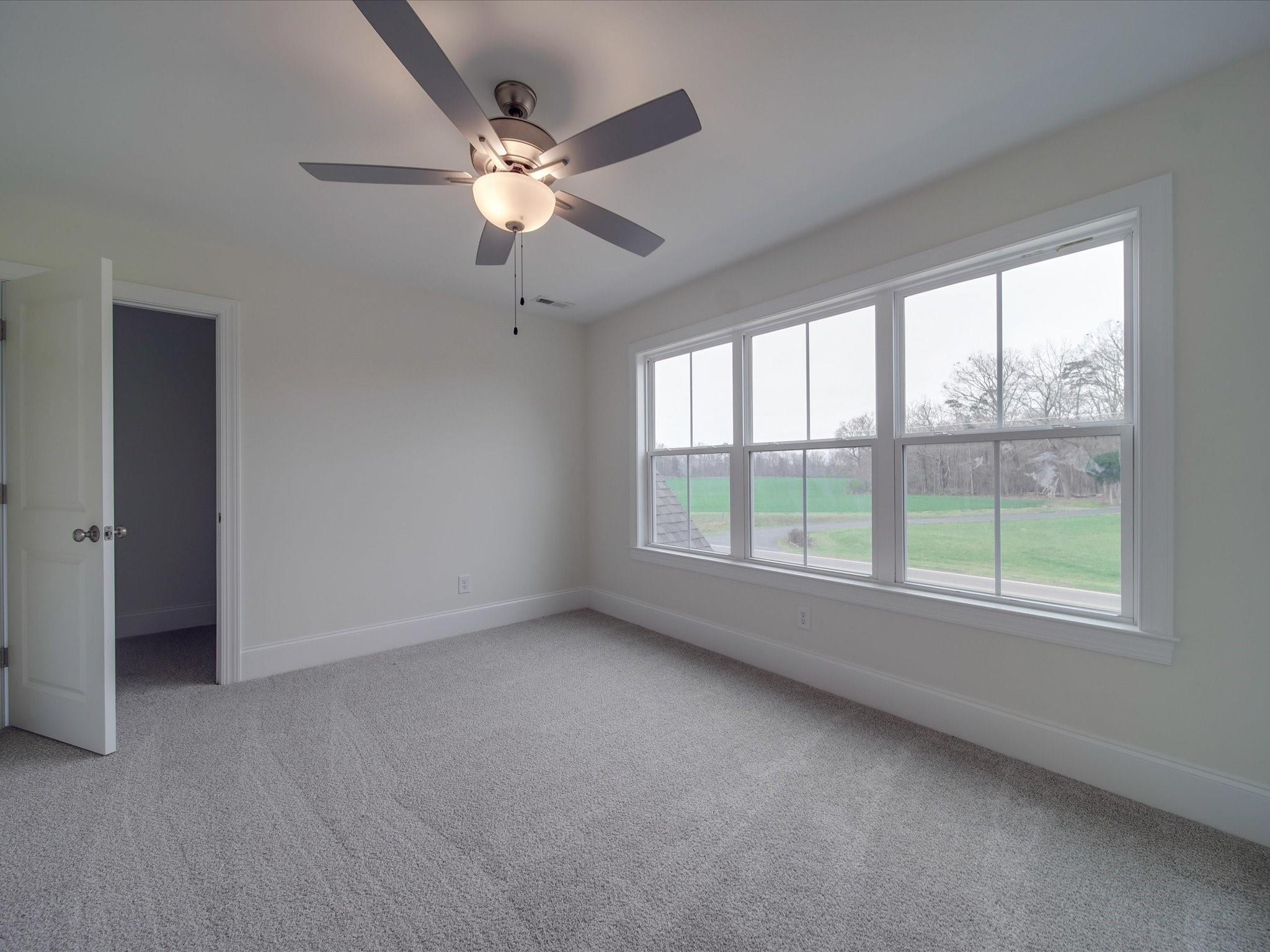 3815 East Brief Road Monroe, NC 28110 - Photo 20 of 46 an empty room with chandelier fan and windows