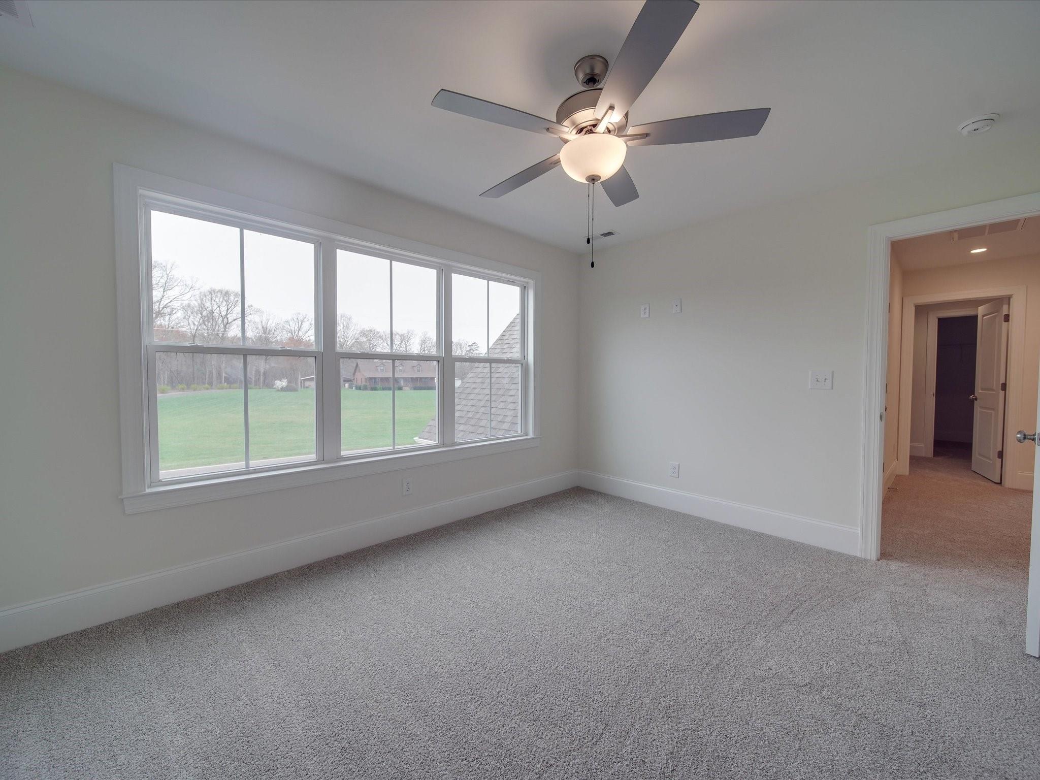 3815 East Brief Road Monroe, NC 28110 - Photo 22 of 46 an empty room with a chandelier fan and windows