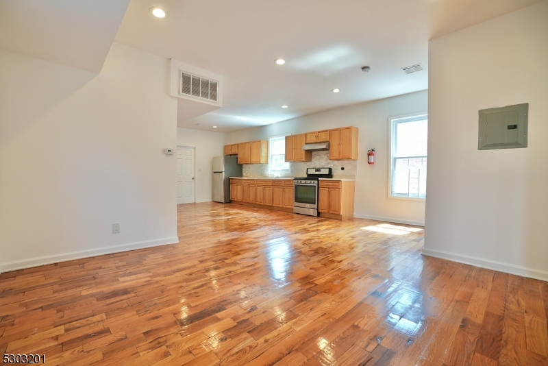 131 Sylvan Avenue Newark, NJ 07104 - Photo 2 of 9 a view of kitchen with cabinets and wooden floor