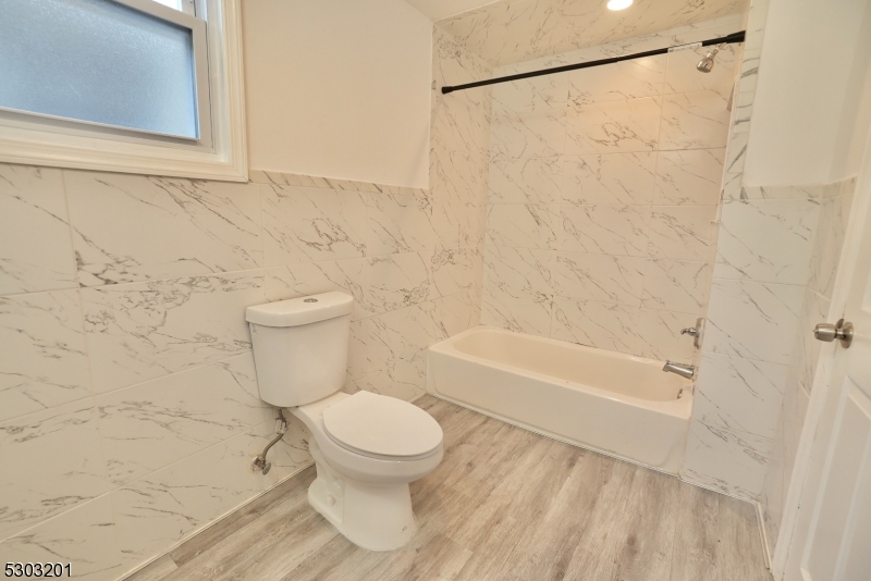131 Sylvan Avenue Newark, NJ 07104 - Photo 9 of 9 a white toilet sitting next to a bath tub and a shower