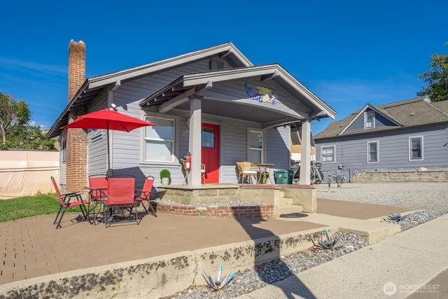 a patio with a table and chairs under an umbrella