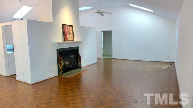 247 Fox Ridge Road Pittsboro, NC 27312 - Photo 5 of 24 The spacious Living Room features vaulted ceiling with skylights, masonry fireplace, and parquet flooring.