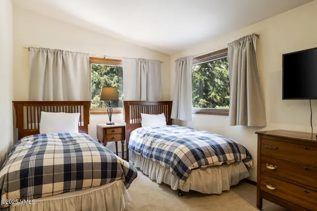 a bedroom with two beds and a flat screen tv