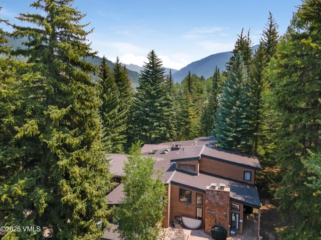 an aerial view of a house with a yard and mountain view in back