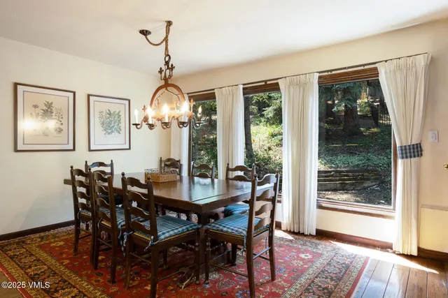 a dining room with furniture a chandelier and wooden floor