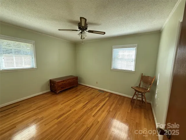 a view of a livingroom with a chair and wooden floor