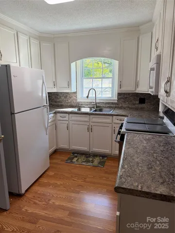 a kitchen with wooden cabinets and white appliances