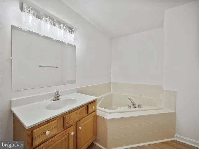 a bathroom with a sink vanity and tub