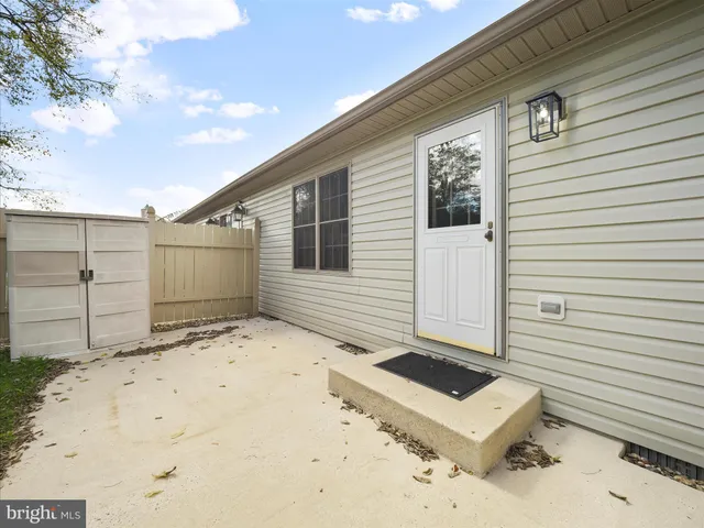 a view of a small house with wooden fence