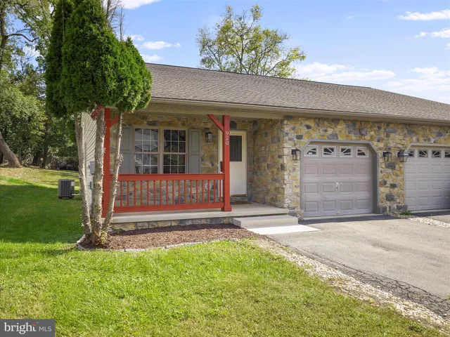 a view of a house with a yard and a large tree