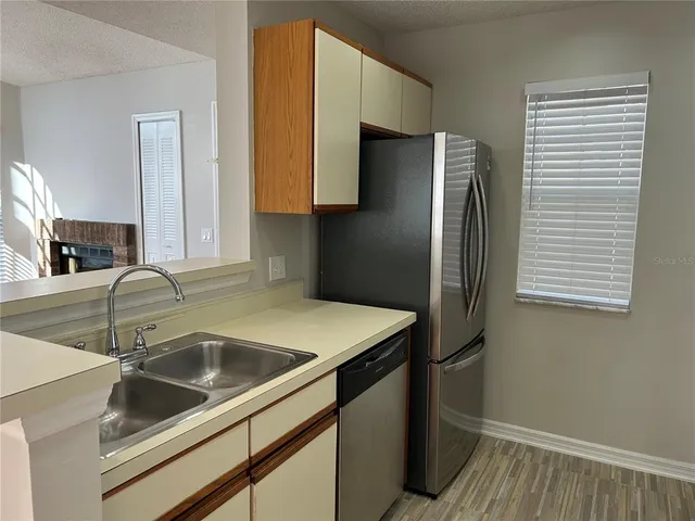a kitchen with stainless steel appliances granite countertop a sink and a refrigerator