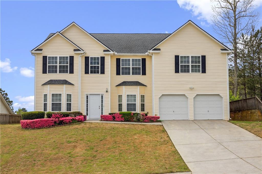 a view of a white house with a yard and large tree