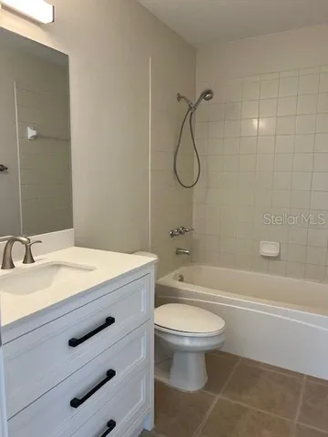 a bathroom with a granite countertop toilet a sink and a bathtub