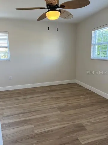 a view of a room with wooden floor and a table chair