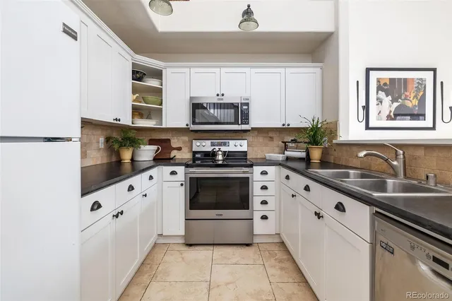 a kitchen with granite countertop a stove top oven sink and cabinets