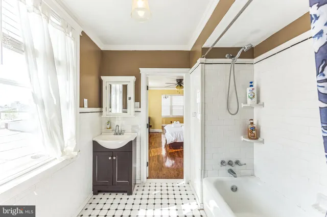 a bathroom with a sink a mirror a bathtub and shower