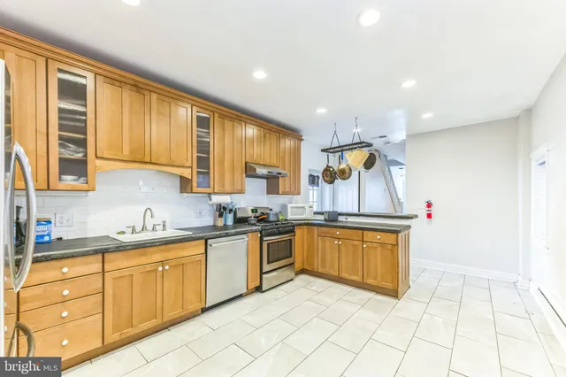 a kitchen with stainless steel appliances granite countertop a stove sink and cabinets