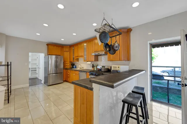 a kitchen with stainless steel appliances granite countertop a sink a stove and a refrigerator