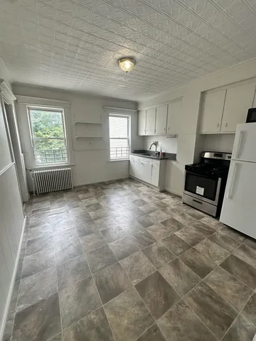 a kitchen with stainless steel appliances a stove a sink cabinets and a window