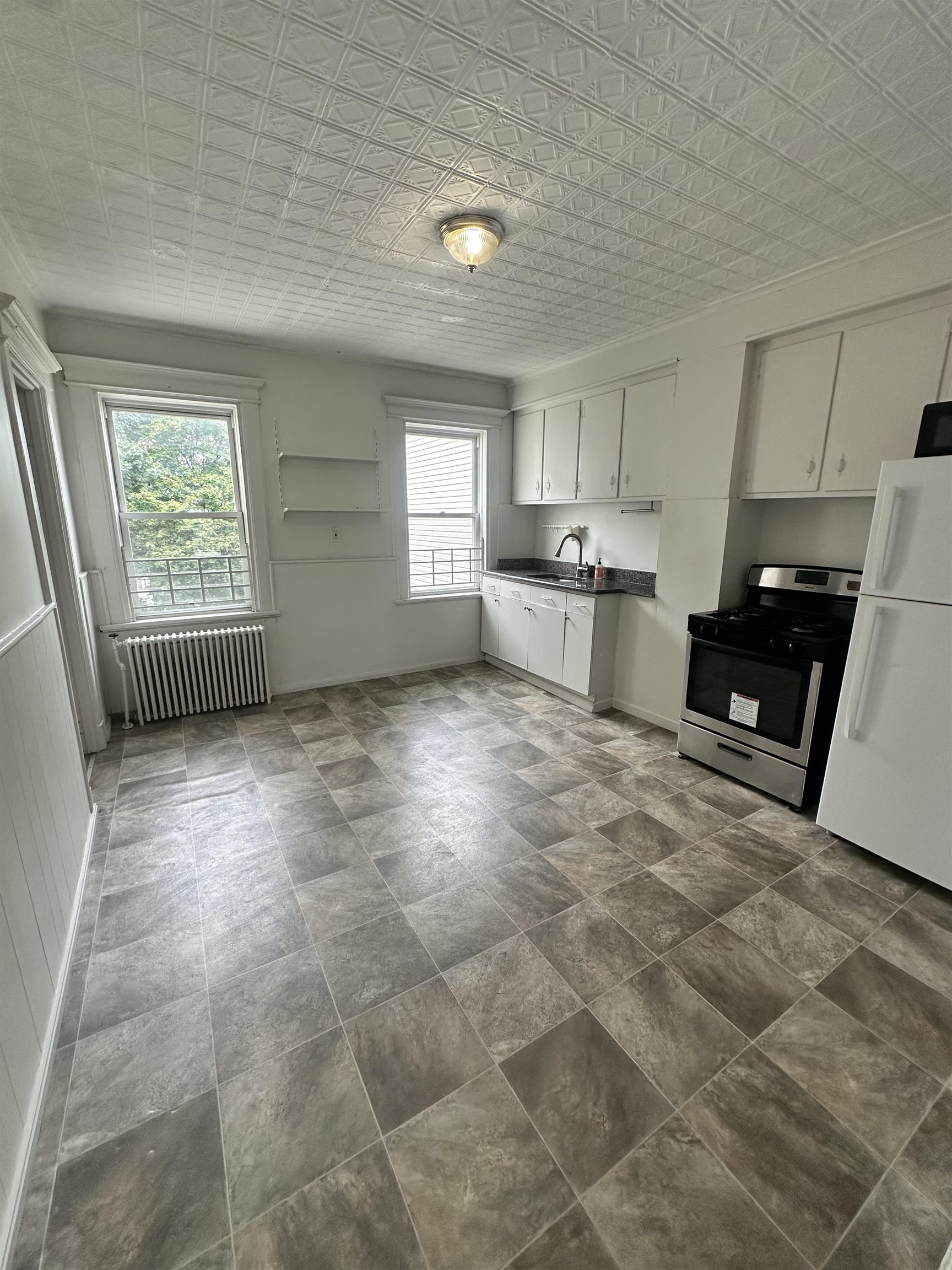 a kitchen with stainless steel appliances a stove a sink cabinets and a window