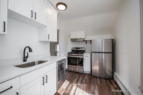 a kitchen with white cabinets and stainless steel appliances