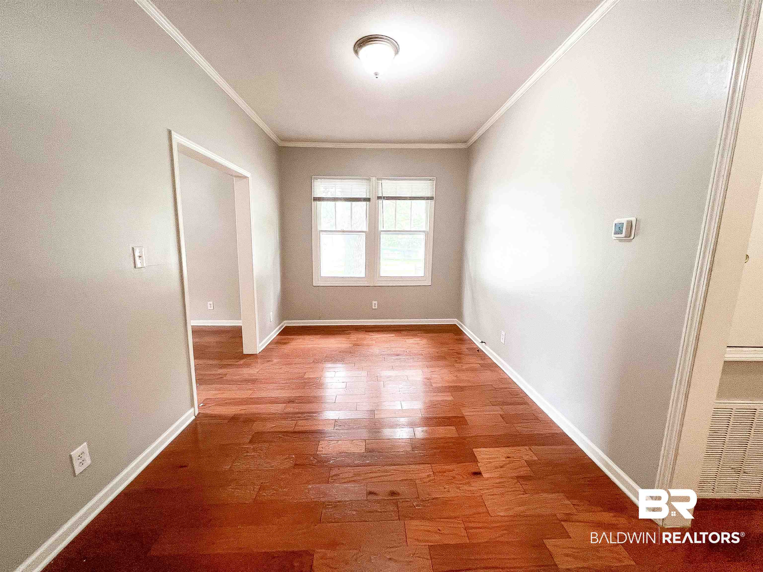 1164 Seneca Street Mobile, AL 36605 - Photo 12 of 22 Spare room with baseboards, ornamental molding, and hardwood / wood-style floors