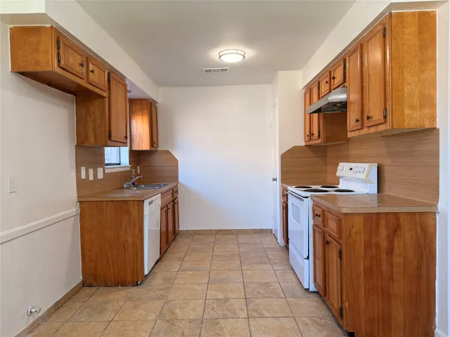 a kitchen with a stove top oven sink and cabinets